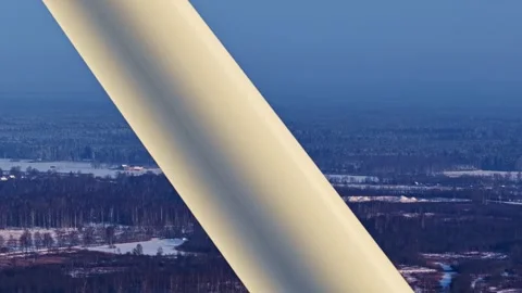 Dramatic Aerial View of a Wind Turbine Blade Over a Snowy Forest Stock Footage 327507728