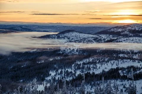 Dramatic aerial view of winter forest and mountains at sunset Stock Photos