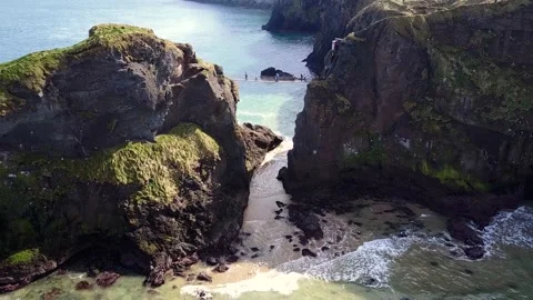 Dramatic Aerial Zoom Out on Carrick-a-Rede Rope Bridge on a Sunny Day Stock Footage