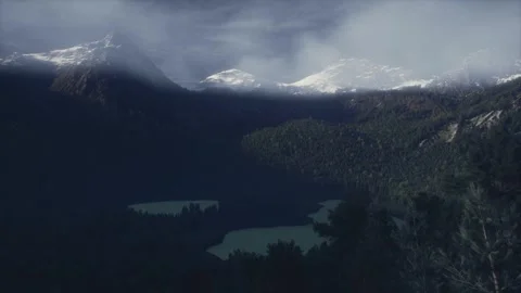 Dramatic alpine lake surrounded by dark pine forest and snowy mountains Stock Footage 338229854