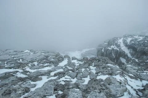 Dramatic alpine rocky plateau in dense fog and snow Stock-Fotos