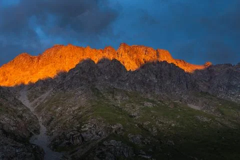 Dramatic alpine sunset with golden light on jagged ridges Stock Photos