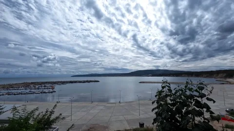 Dramatic altocumulus clouds moving over a sea harbor Byala Bulgaria Stock Footage 346411009