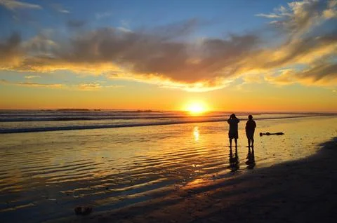 Dramatic and beautiful setting sun at sunset beach Stock Photos