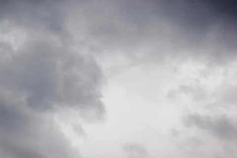 A dramatic and moody sky filled with thick, dark grey storm clouds creating.. Stock Photos