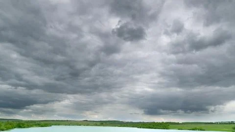 A Dramatic and Overcast Cloudy Sky Spreads Across a Calm and Tranquil Water Land Stock Photos