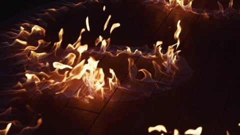 Dramatic and Vibrant Flames Dancing Gracefully on the Floor in a Dark and Stock Footage 304264906