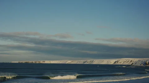 Dramatic Arctic sunrise over Iceland’s tundra with snowy plains and ocean waves Stock Footage 305426122