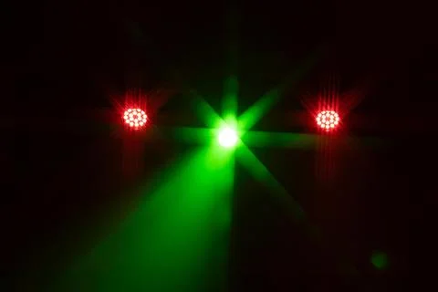 A dramatic array of yellow and purple stage lights creates vivid starburst. Stock Photos