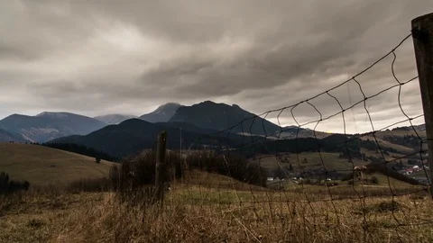 Dramatic autumn clouds over rural landscape. Dolly shot over fence and dry grass Stock Footage 86098597
