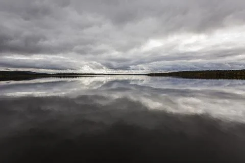 Dramatic autumn clouds reflection in Muonio lake, Lapland, Northern Finland Stock Photos