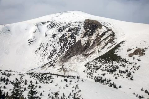 A dramatic avalanche scar gouges a snow-covered mountainside Stock Photos