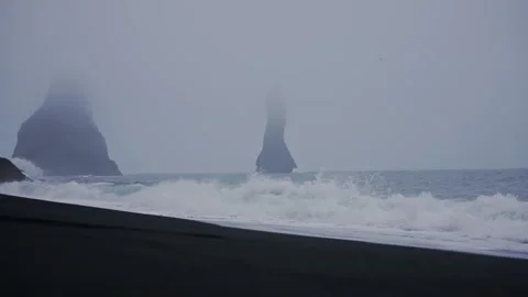 Dramatic Basalt Sea Stacks in Misty Icelandic Coastal Waters with Black Sand Bea Stock Footage 341295071