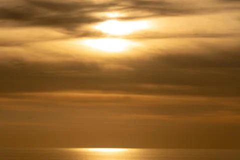 Dramatic beautiful sunset in the coast. Orange dramatic colours on cloudy sky Stockfoto's