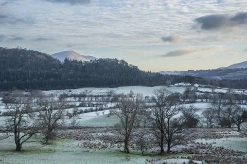 Dramatic beautiful Winter landscape image looking across countryside in Lak.. Stock Photos