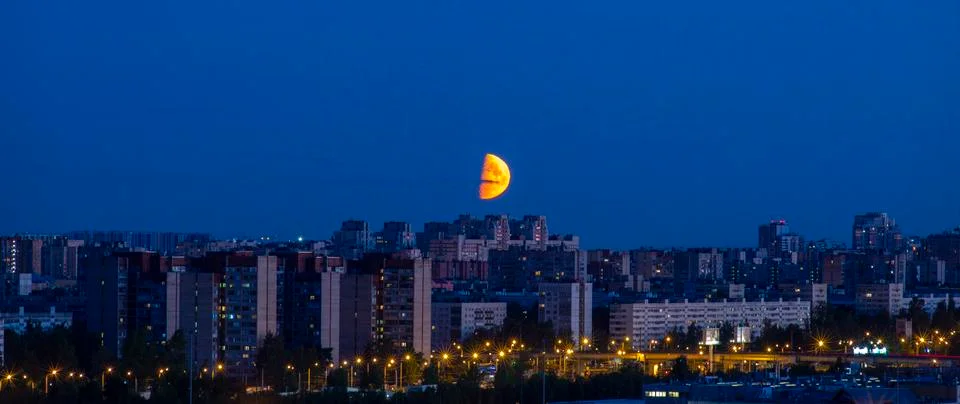 Dramatic Big red moon over the city. Summer night. Clear sky. Stock Photos