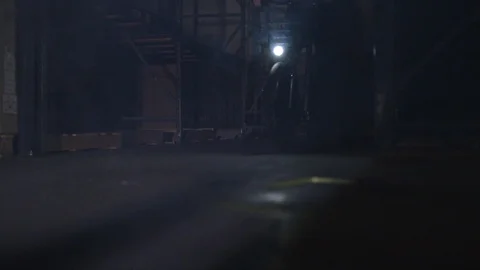 Dramatic bike riding through a dark warehouse Stock-Footage 91920722