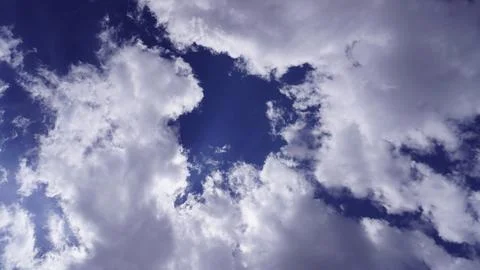 Dramatic billowing white and gray clouds against a deep blue sky, grand. Stock Photos