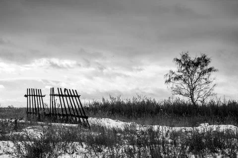 Dramatic black and white landscape in the form of a destroyed old fence and a Stock Photos