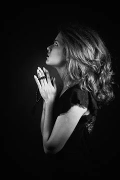Dramatic black and white portrait of a  woman  praying or thinking emerging f Stock Photos