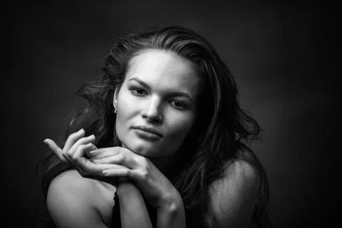 Dramatic black and white portrait of a beautiful girl on a dark background Stock Photos