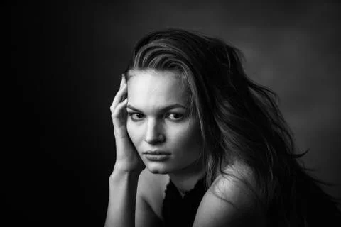 Dramatic black and white portrait of a beautiful girl on a dark background Stock Photos