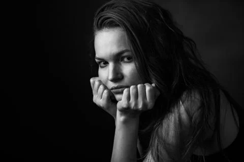 Dramatic black and white portrait of a beautiful girl on a dark background Stock Photos