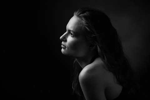 Dramatic black and white portrait of a beautiful girl on a dark background Stock Photos