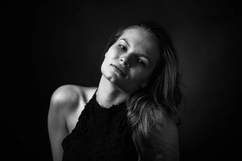 Dramatic black and white portrait of a beautiful girl on a dark background Stock Photos