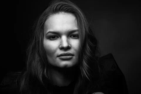 Dramatic black and white portrait of a beautiful girl on a dark background Stock Photos