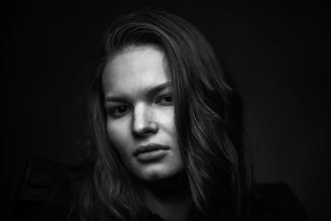 Dramatic black and white portrait of a beautiful girl on a dark background Stock Photos
