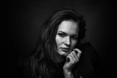 Dramatic black and white portrait of a beautiful girl on a dark background Stock Photos