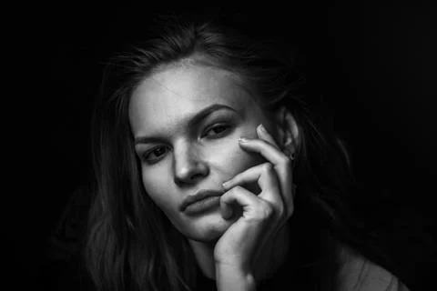 Dramatic black and white portrait of a beautiful girl on a dark background Stock Photos