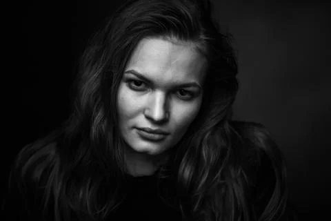 Dramatic black and white portrait of a beautiful girl on a dark background Stock Photos