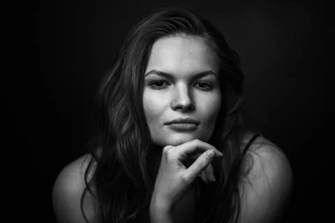 Dramatic black and white portrait of a beautiful girl on a dark background Stock Photos