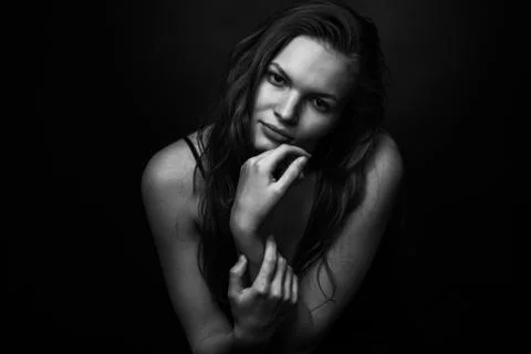 Dramatic black and white portrait of a beautiful girl on a dark background Stock Photos