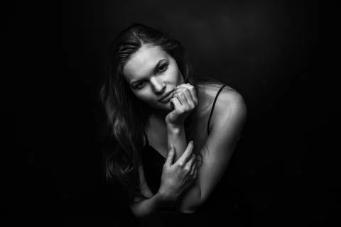 Dramatic black and white portrait of a beautiful girl on a dark background Stock Photos