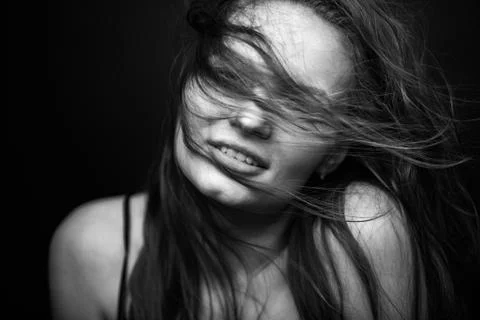 Dramatic black and white portrait of a beautiful girl on a dark background Stock Photos