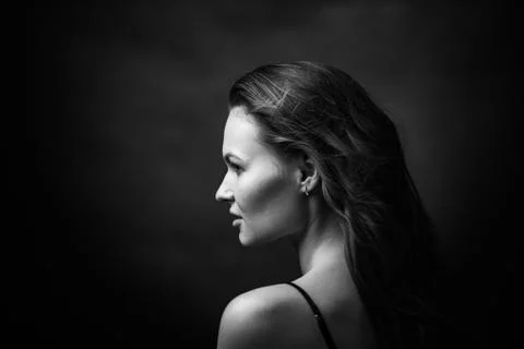 Dramatic black and white portrait of a beautiful girl on a dark background Stock Photos