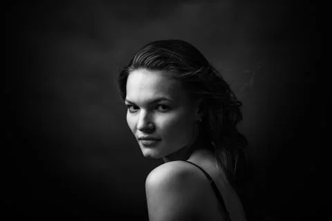 Dramatic black and white portrait of a beautiful girl on a dark background Stock Photos