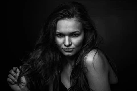 Dramatic black and white portrait of a beautiful girl on a dark background Stock Photos