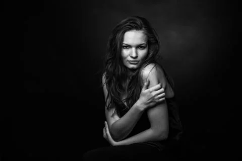 Dramatic black and white portrait of a beautiful girl on a dark background Stock Photos