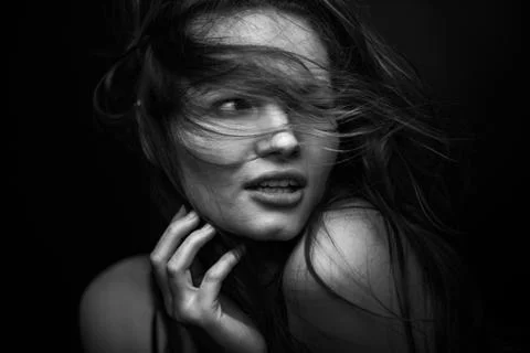 Dramatic black and white portrait of a beautiful girl on a dark background Stock Photos
