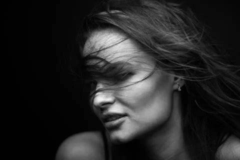 Dramatic black and white portrait of a beautiful girl on a dark background Stock Photos