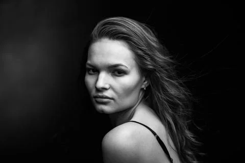 Dramatic black and white portrait of a beautiful girl on a dark background Stock Photos