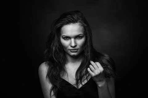 Dramatic black and white portrait of a beautiful girl on a dark background Stock Photos