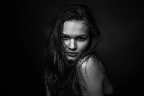 Dramatic black and white portrait of a beautiful girl on a dark background Stock Photos