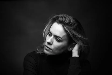 Dramatic black and white portrait of a beautiful woman on a dark background Stock Photos
