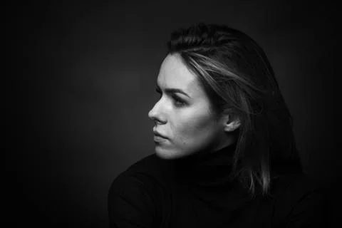 Dramatic black and white portrait of a beautiful woman on a dark background Stock Photos