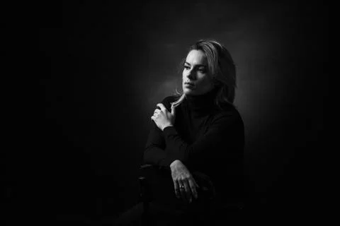 Dramatic black and white portrait of a beautiful woman on a dark background Stock Photos